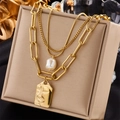 Collana dorata multistrato vintage con perle e pendente a volto su portagioie - Oro