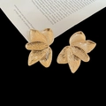 Macro detail of golden layered flower petal earrings with textured metallic finish - Gold