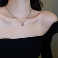 Close-up of a silver heart and star pendant necklace worn by a model in a dark setting - 粉色心形(38#项链)
