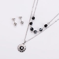 Close-up of silver steel jewelry set featuring concentric circle pendant and stud earrings - Steel Black
