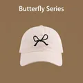 Detail of pink cotton sun hat featuring black butterfly embroidery and UV protection - Front Bowknot Embroidery Baseball Cap / Rice Black