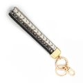 Handmade woven wrist strap keychain in black, white, and gray with golden ring - Black