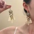 Detail of bohemian long tassel earrings with vintage gold metal disc and white cotton fringe - Vintage Metal Leaf Cotton (18#)