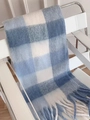 Blue and white checkered plaid fringe scarf draped on a modern chair in an indoor setting - Sky Blue Rainbow