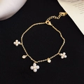 Detailed view of elegant gold floral bracelet with white pearls and sparkling zircons - Gold