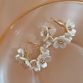Detalle de pendientes de aro dorados con flores de acrílico blanco y centros de cristal - Pin de Plata Flor Dorada Aro en C