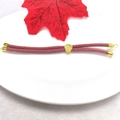 Macro detail of pink braided Milan cord bracelet with 18k gold-plated cylinder bead - Pink Purple