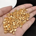 Golden irregular geometric spacer beads for DIY jewelry held in hand showing texture - 06 (5.7mm Geometric Irregular Bead)