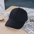 Detailed view of a classic black cotton baseball cap on a wooden table with lifestyle props - Black