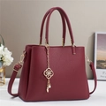 Bolso de mano en cuero burdeos granulado con herrajes dorados y cadena decorativa floral - Rojo