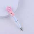 Dettaglio penna bianca fai-da-te con perline, fiore in silicone rosa e sfere geometriche - Rosa