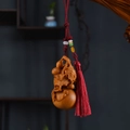 Macro detail of hand-carved wooden gourd pendant with red tassel and lucky beads - Aged Cypress Five Blessings Red Tassel