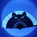 Detail of folding fan showing black cat face with glowing eyes and black polka dots - Black Cat Polka Dot UV Glow A32