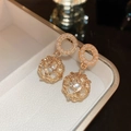 Detalle macro de pendientes de jaula dorada con perlas en un estuche de joyería - Estilo de Perla con Rejilla Dorada