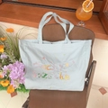 Mintgrüne Canvas-Einkaufstasche mit Lucky Sozakka-Stickerei auf einem Klappstuhl - Hellblau