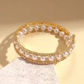 Détail d'un bracelet triple épaisseur doré avec perles blanches et strass étincelants - Style Spirale à Trois Couches / Doré