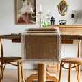 Detail of natural jute table runner with white lace trim on rustic wooden surface - Wide Lace Edge