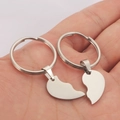 Minimalist stainless steel couple's heart keychain set held in hand with silver finish - Key Ring / Steel
