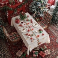 Beige Christmas tablecloth with festive embroidery on a dining table with holiday decor - Bell Candle