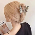 Macro shot of a silver metal bat-shaped hair claw clip styling a sleek bun hairstyle - Black Bat / White Gold