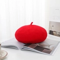 Klassische rote Baskenmütze aus Wolle auf einem Marmortisch mit Magazin für ein Mode-Look - Einheitsgröße / Rot