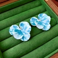Nahaufnahme der blauen Emaille-Blumenohrringe mit Kristall auf grünem Samt - Blaue Blumen-Ohrstecker (Silbernadel)