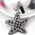 Detalle de llavero de estrella de mar con pedrería blanca y negra y un fleco negro - Negro