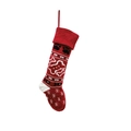 Detail view of red knitted Christmas stocking with white bone and pet paw prints - Red
