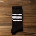 Chaussettes rétro en coton noir avec trois rayures blanches sur fond en bois naturel - Taille Unique / Rayé Blanc