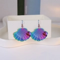 Détail de boucles d'oreilles irisées en forme de coquillage avec motifs ajourés précis - Coquille Irisée