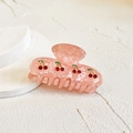 Pink marble hair claw clip with red cherry patterns on a white display stand - Pink Cherry Style