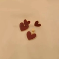 Burgundy enamel heart earrings with gold trim on a beige textured background - Burgundy