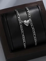 Detail of magnetic heart pendants on Figaro chains displayed in a wooden gift box - Silver