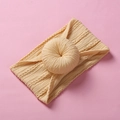 Detail of yellow nylon donut headband with twisted knot design on pink background - Light Yellow