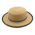 Dettaglio del cappello paglia con bordo nero e nastro decorativo di perle eleganti - Stile Perla Cachi