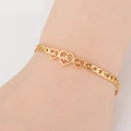 Close-up of golden stainless steel heart bracelet with heartbeat motif on a wrist - 3 Hearts EKG / Gold