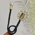 Bigoudi noir élégant avec de grandes perles et des accents floraux en strass brillants - Cygne Rond