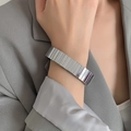 Bracciale in argento stile cinturino d'orologio indossato con un abito grigio elegante - Argento