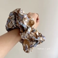 Vista dettagliata dell'elastico scrunchie in seersucker con motivi floreali vintage Monet - Caffè Sfumato