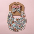 Detail eines floralen Boho Baby Lätzchens mit Bommelsaum und passenden Stirnbändern - Rosa Blumenmuster Stil (2)