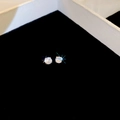 Gros plan de boucles d'oreilles en zircone étincelantes sur monture en argent à griffes - 4mm / Argenté