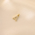 Macro shot of gold letter A pendant with cubic zirconia stones on cream satin - Letter A / Gold