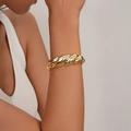 Polished gold croissant style twisted bangle bracelet shown on a model's wrist - Croissant Style Twisted Bangle (SL232) / Gold