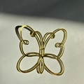 Gros plan d'un papillon en acrylique doré évidé pour la décoration de gâteaux de fête - 4 Papillons Dorés