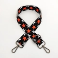 Close-up of thick adjustable crossbody strap with orange stars and metal lobster clasps - Black Base Orange Star Gunmetal Buckle