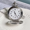 Detail of vintage Alice quartz pocket watch in silver on decorative white plate - Silver