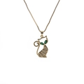 Detail of gold cat pendant with green gemstone eyes and clear crystals on a titanium chain - Green