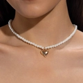 Close-up of elegant pearl necklace with a polished gold heart pendant on model - Gold Heart Pendant Pearl Necklace
