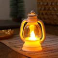 Close-up of a white vintage LED lantern placed on sheet music with warm glowing light - White