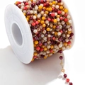 Dettaglio macro di perle sfaccettate colorate su una catena per gioielli fai-da-te oro - Oro-Rosso Multi